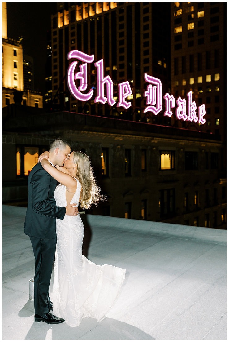 Newlyweds kiss on rooftop in front of The Drake Hotel sign