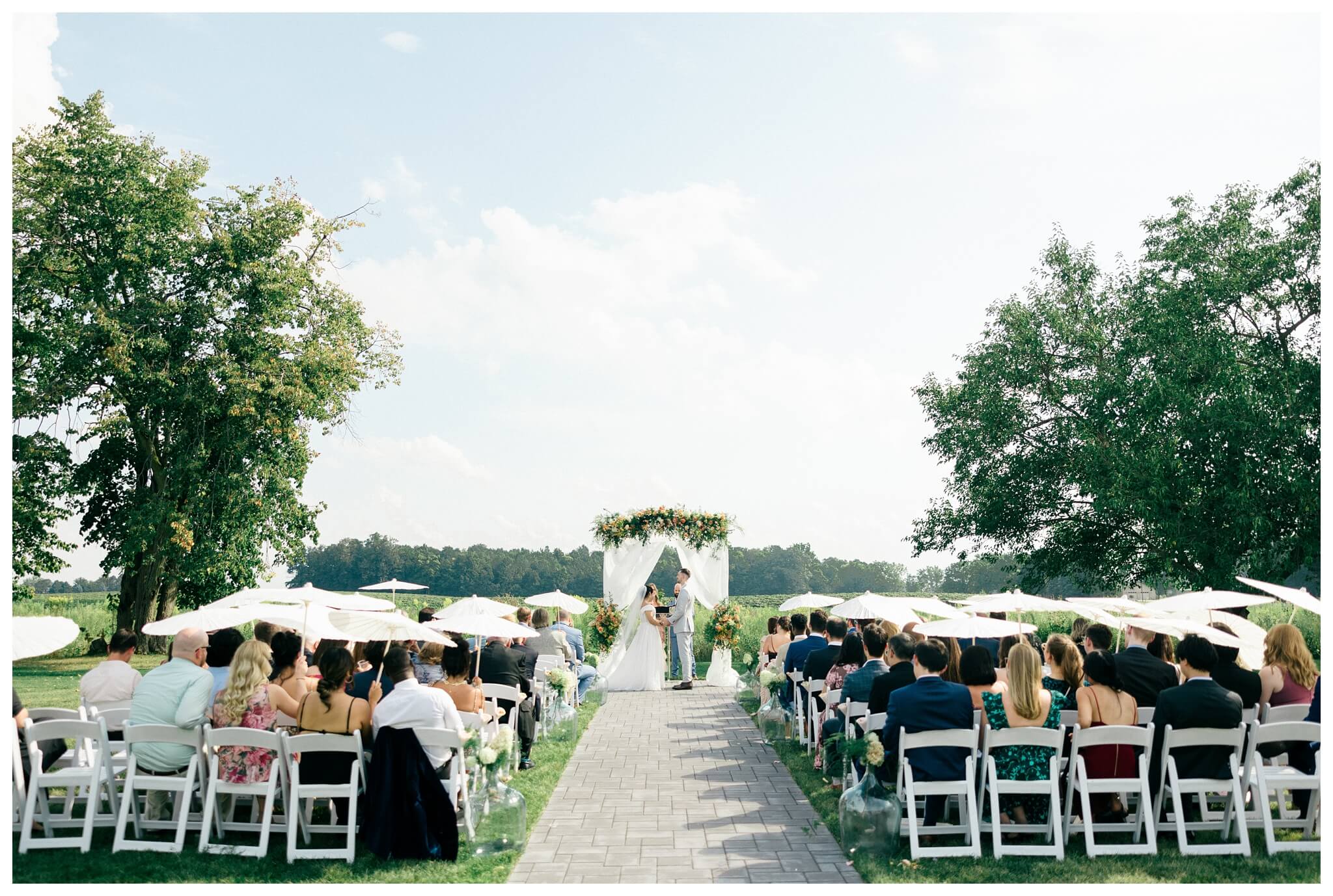 white barn wedding with parasols at etre farms in saint joseph michigan by josh and andrea photography