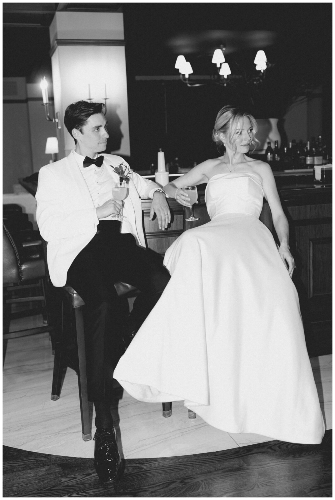 Newlyweds lean on bar at Colony Club wedding