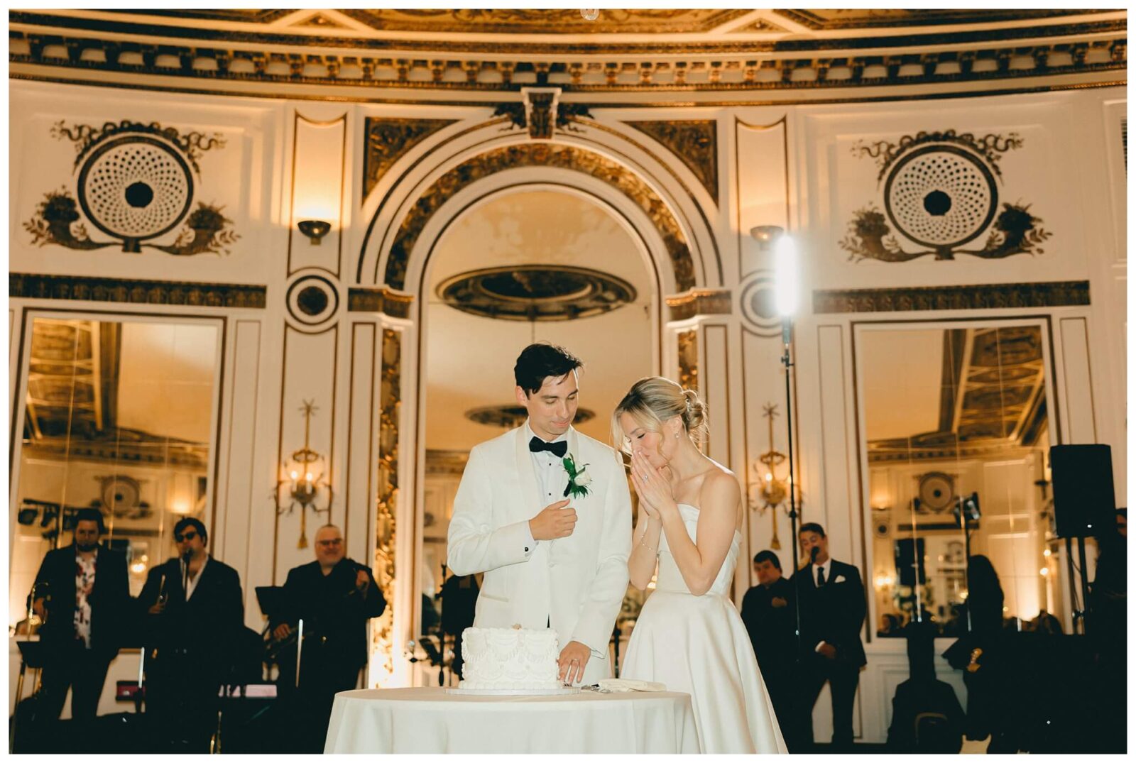 Newlyweds prepare to cut cake at Colony Club wedding