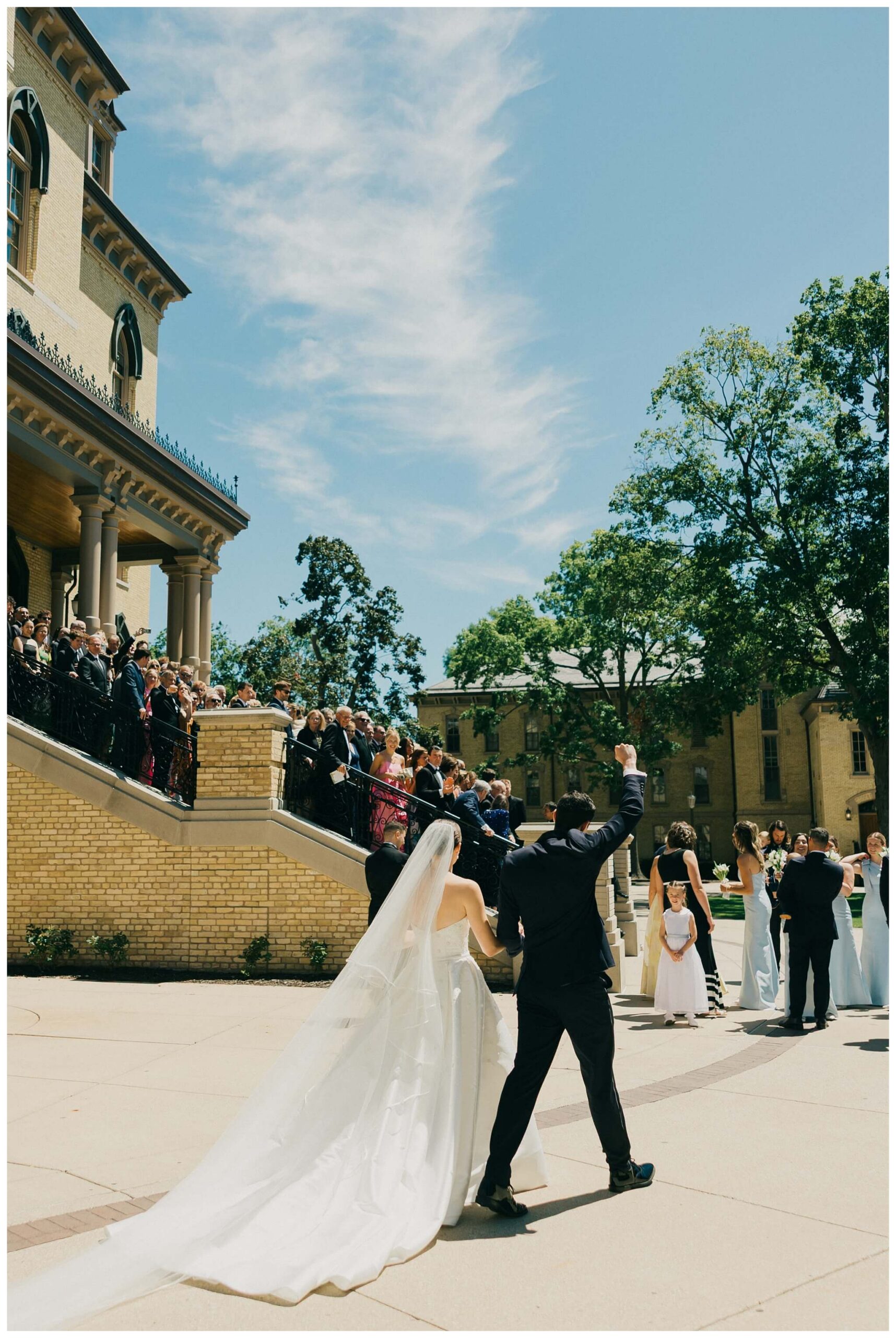 bride and groom group portrait on the main building steps at Notre dame indiana by josh and andrea photography