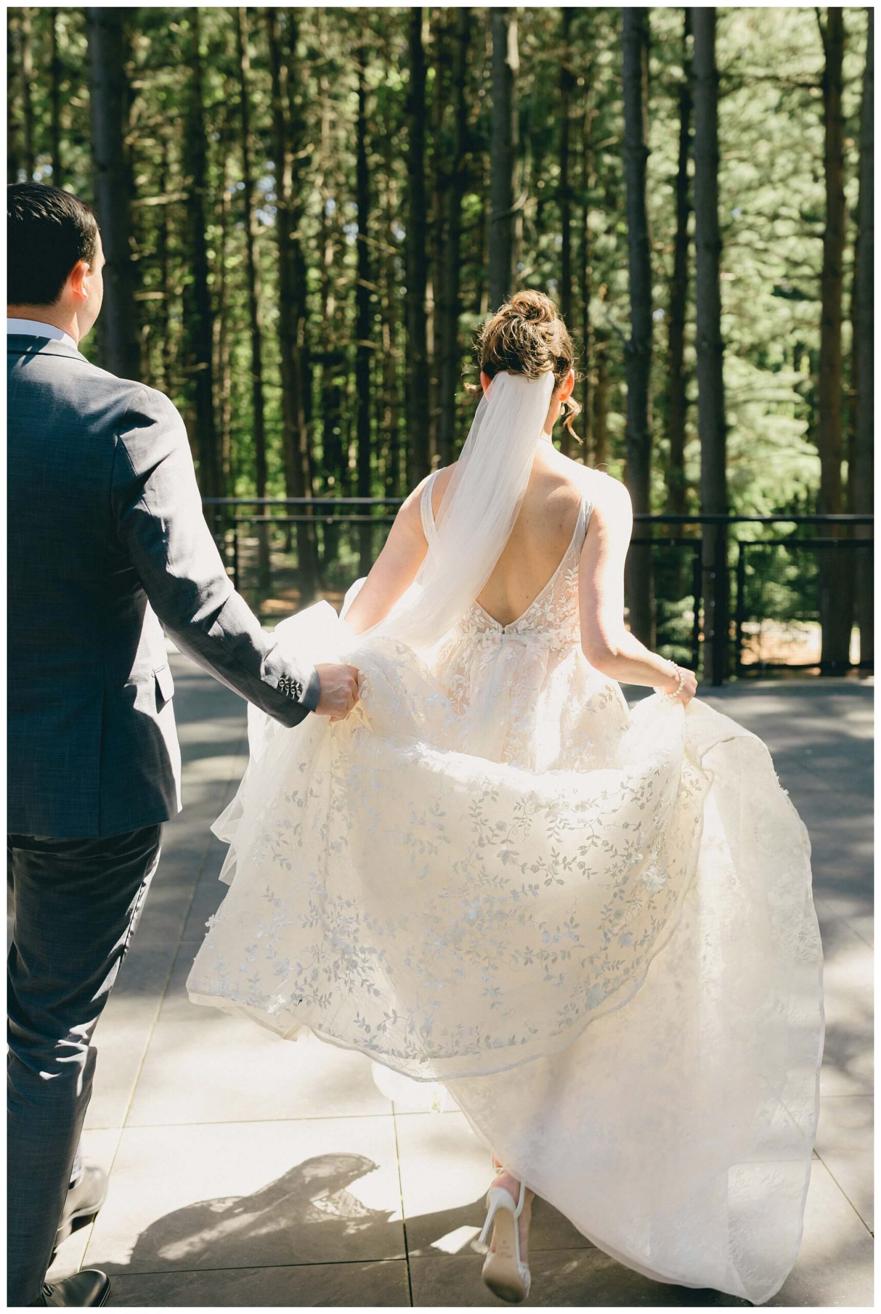 bride and groom walking on back patio at Shepherd's hollow golf club near clarkston michigan by josh and andrea photography 