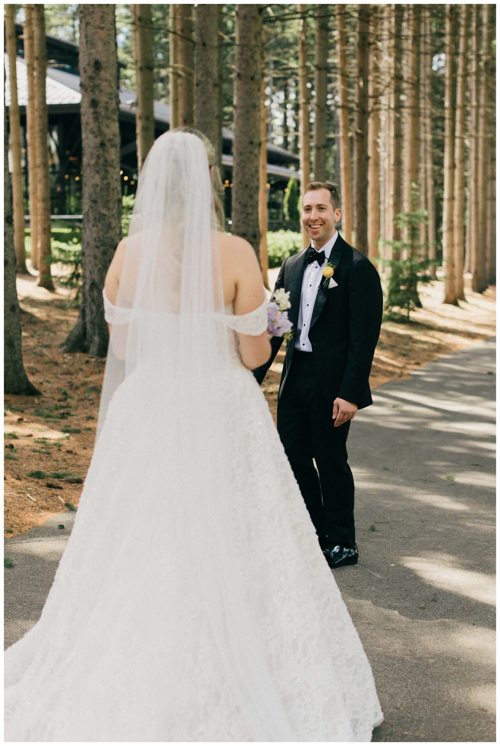 bride and groom share a first look in the trees at Shepherd's hollow golf club near clarkston michigan by josh and andrea photography 