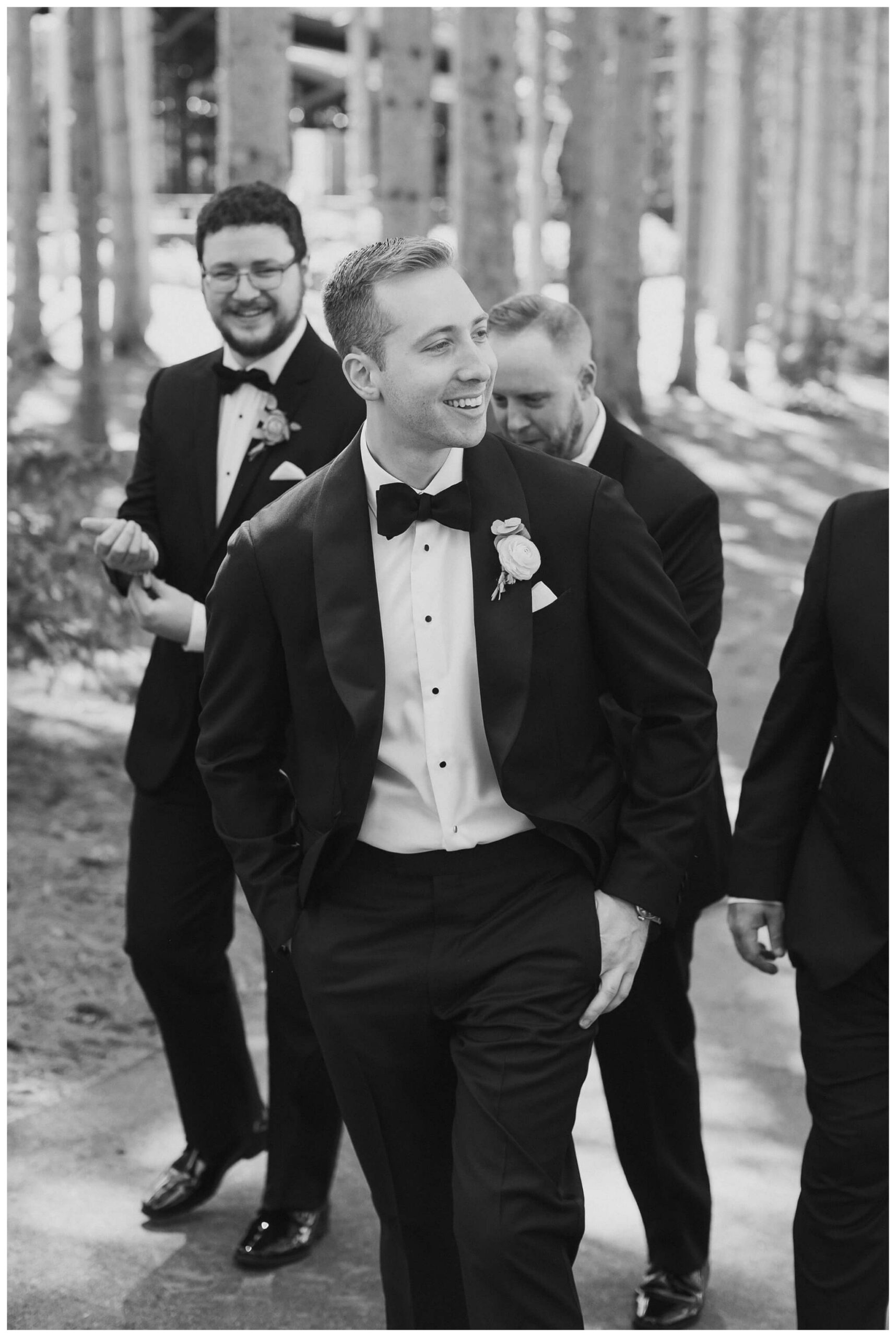 groom and groomsmen walking in the trees at Shepherd's hollow golf club near clarkston michigan by josh and andrea photography 