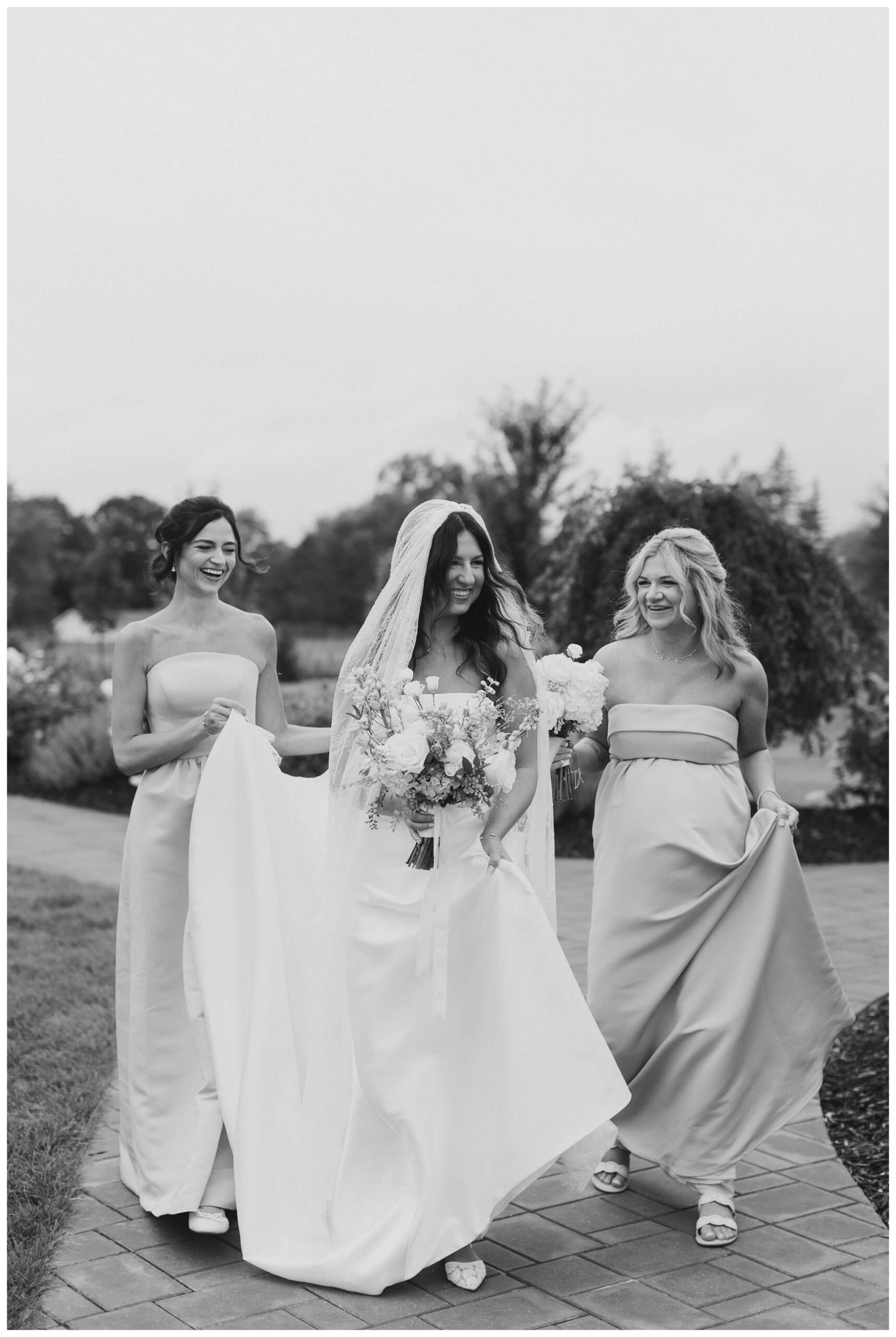 bride and bridesmaids walking to ceremony at white barn wedding at etre farms by josh and andrea photography 