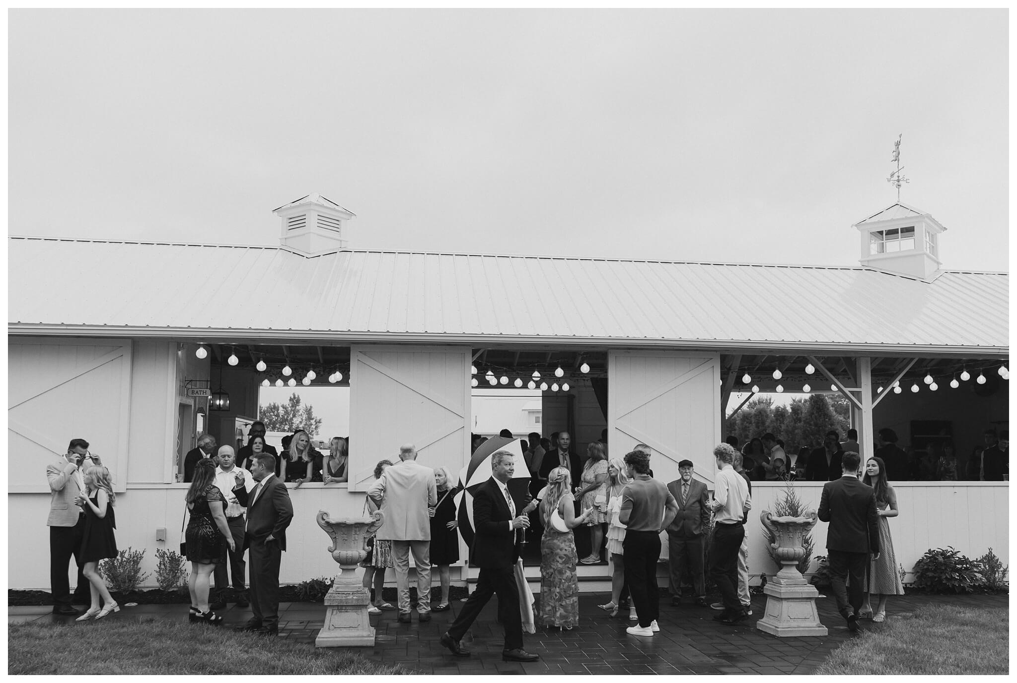 guests get ready for rainy ceremony at white barn wedding at etre farms by josh and andrea photography 