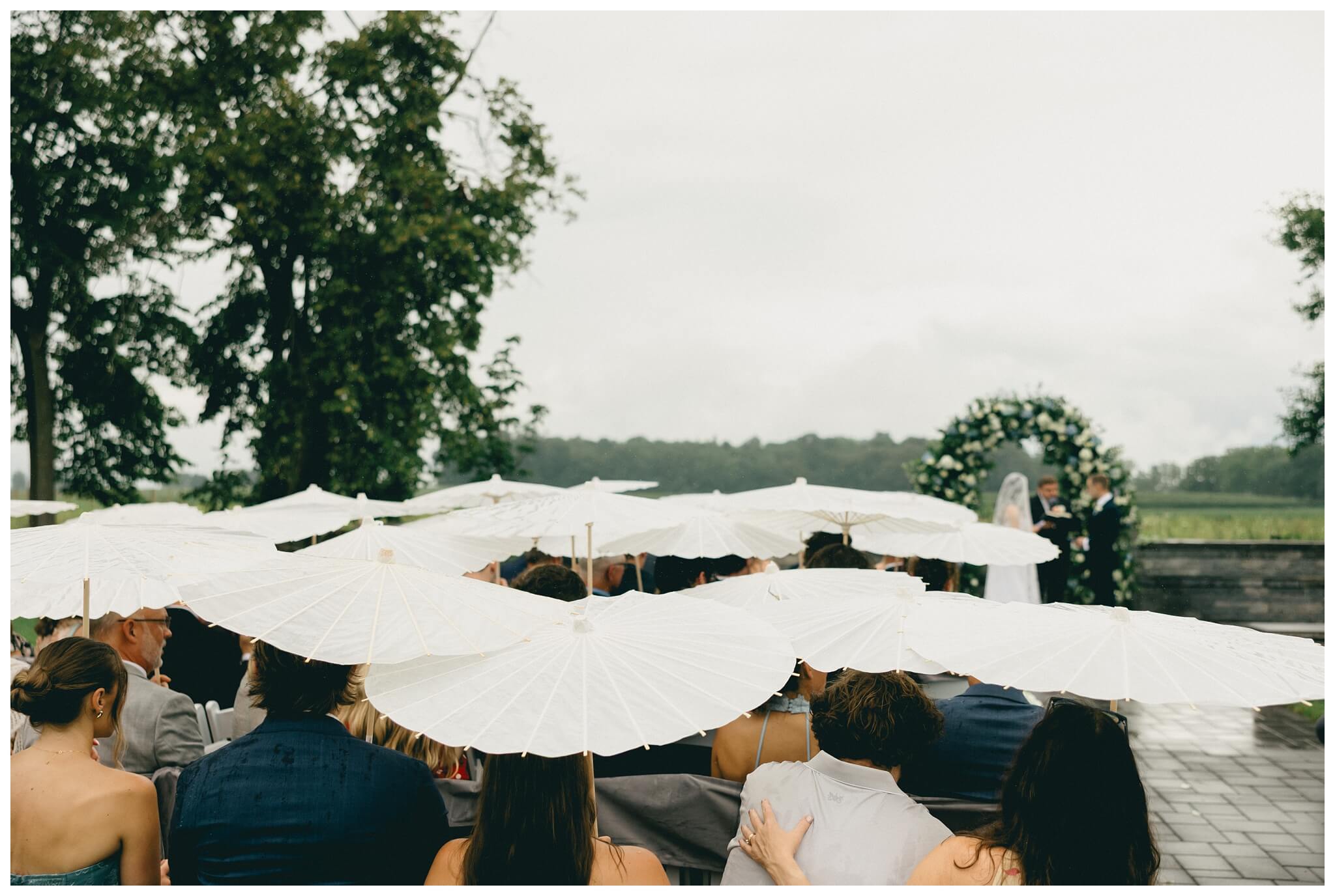 parasols in the rain for ceremony at white barn wedding at etre farms by josh and andrea photography 